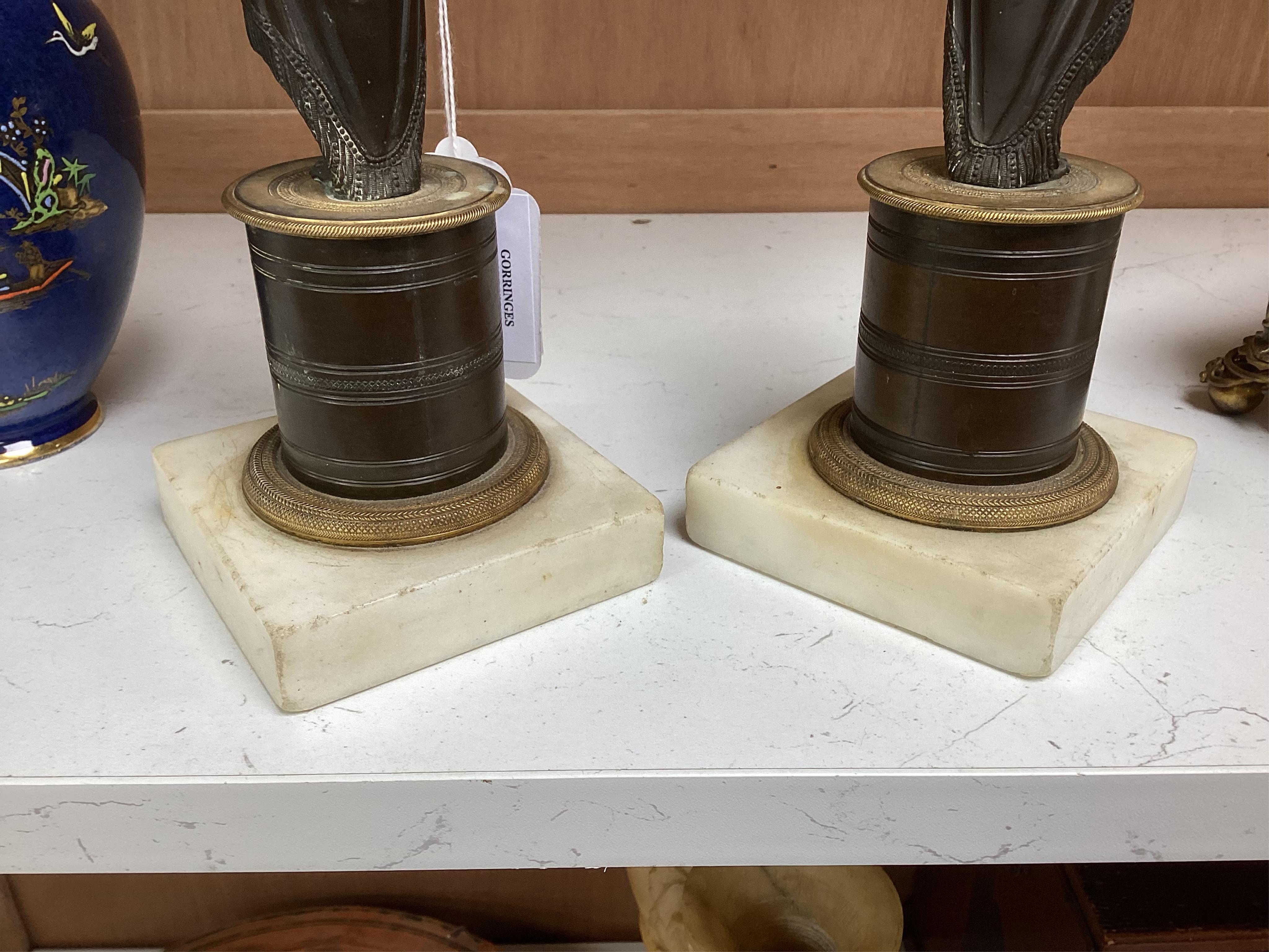 A pair of Regency bronze and gilt candlesticks in the form of standing classical figures mounted on marble bases, 31.5cm high.